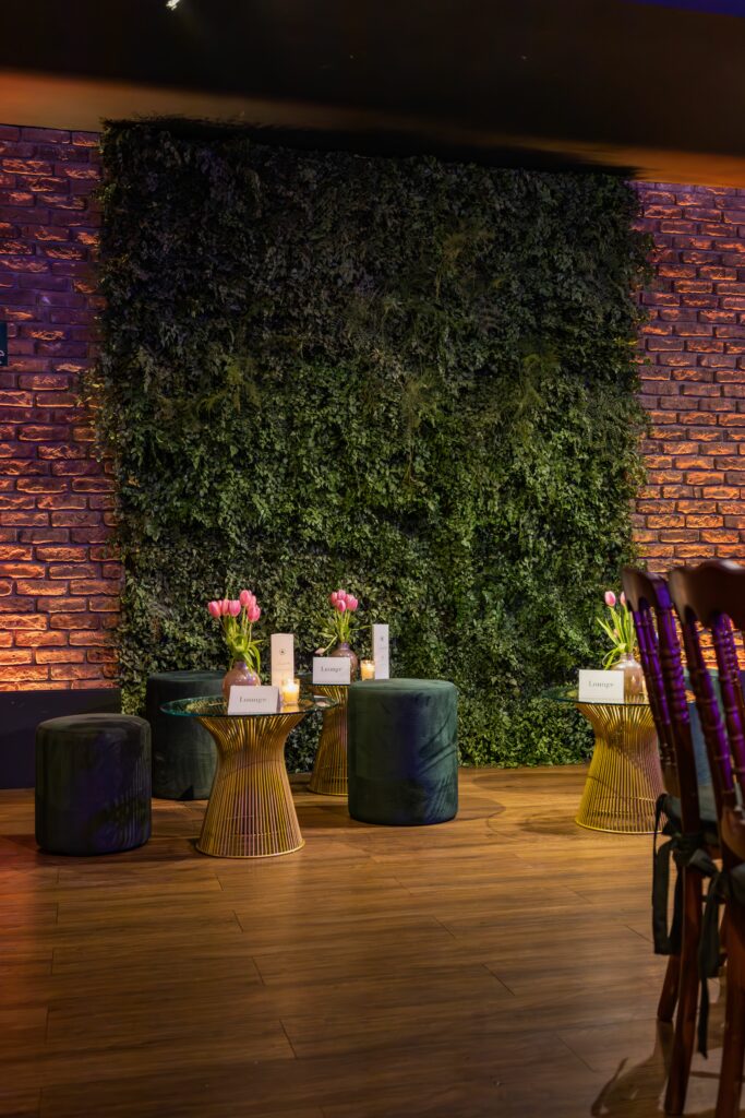 Luxurious lounge with stylish decor, green wall, and ambient lighting, perfect for events.